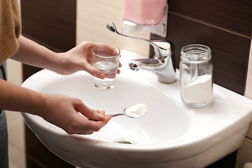 A woman using baking soda to clear a sink in an Erlanger, KY home.