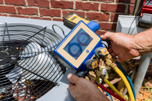 A technician checking the refrigerant levels in an air conditioner unit.