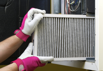 A person replacing a dirty air filter.