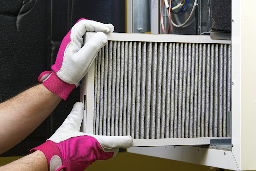 A person replacing a dirty air filter.