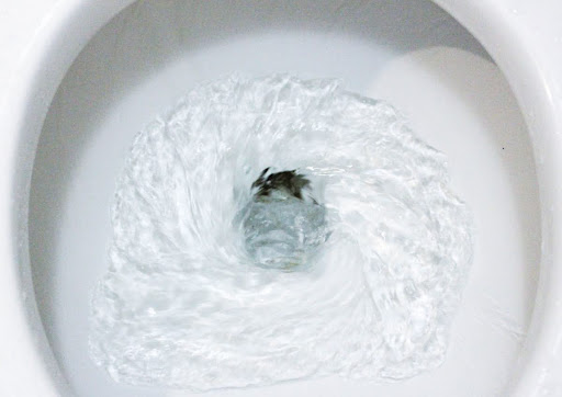 A toilet bowl with swirling water.