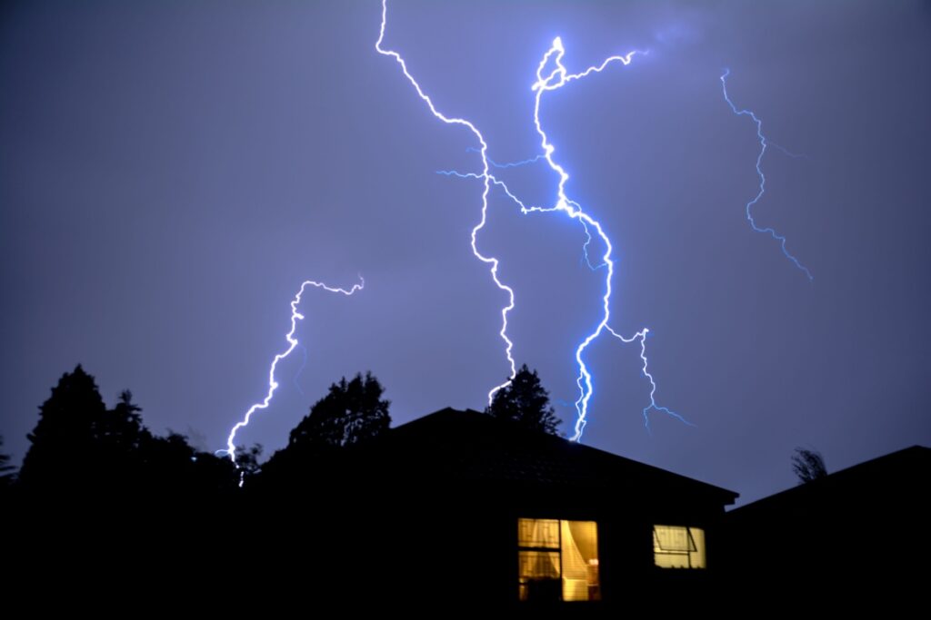 A house with lightning in the background.