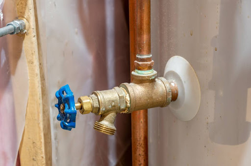 A close-up of a water heater drain valve.