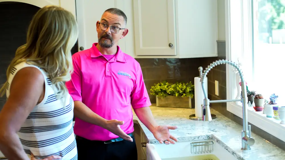 Technician talking to the customer infront of a sink