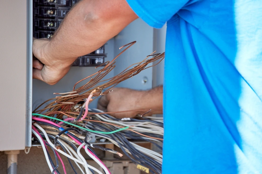 Technician rewiring electrical panel