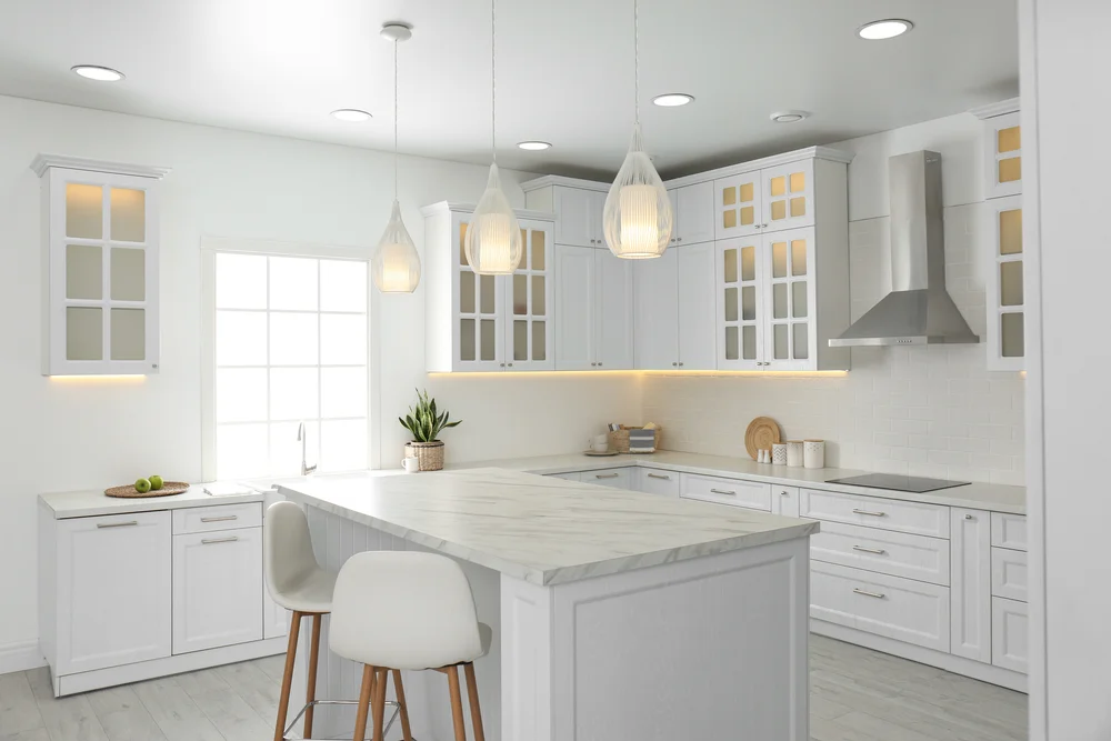 A clean kitchen with hanging ceiling lights